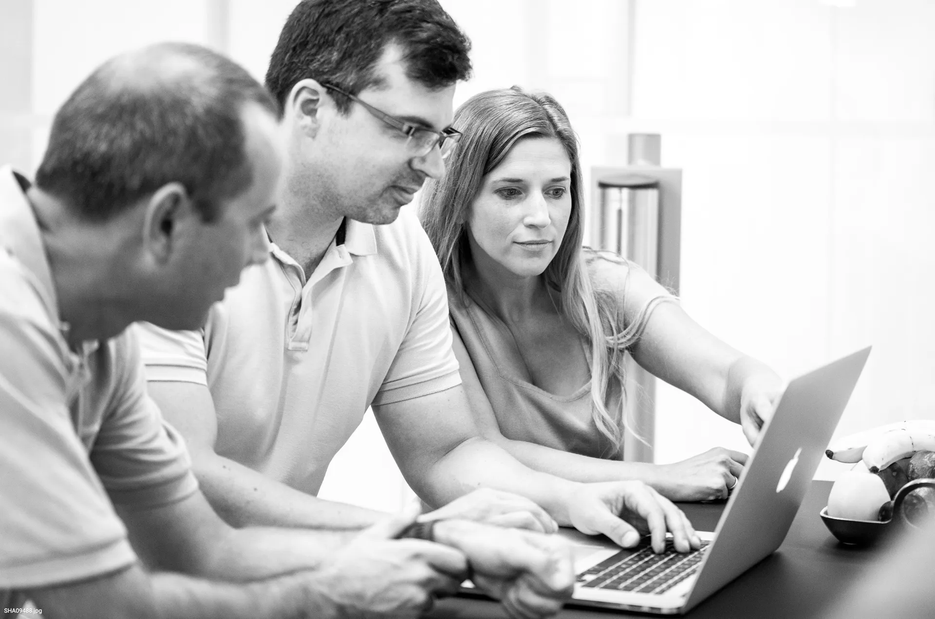 Group of advertising professionals viewing a report together to show the ease of sharing information.